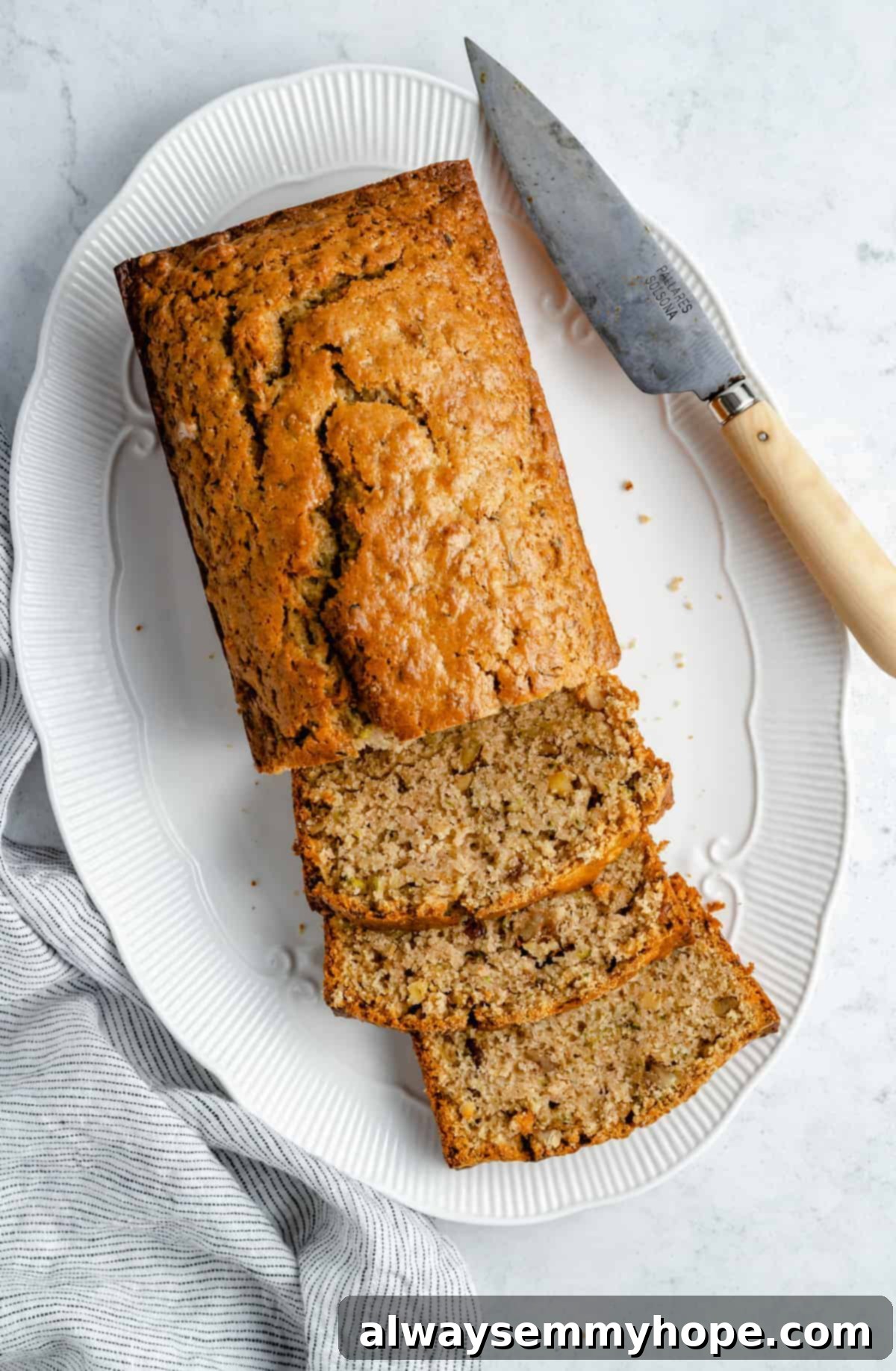 A beautifully sliced loaf of vegan zucchini bread on a cutting board.
