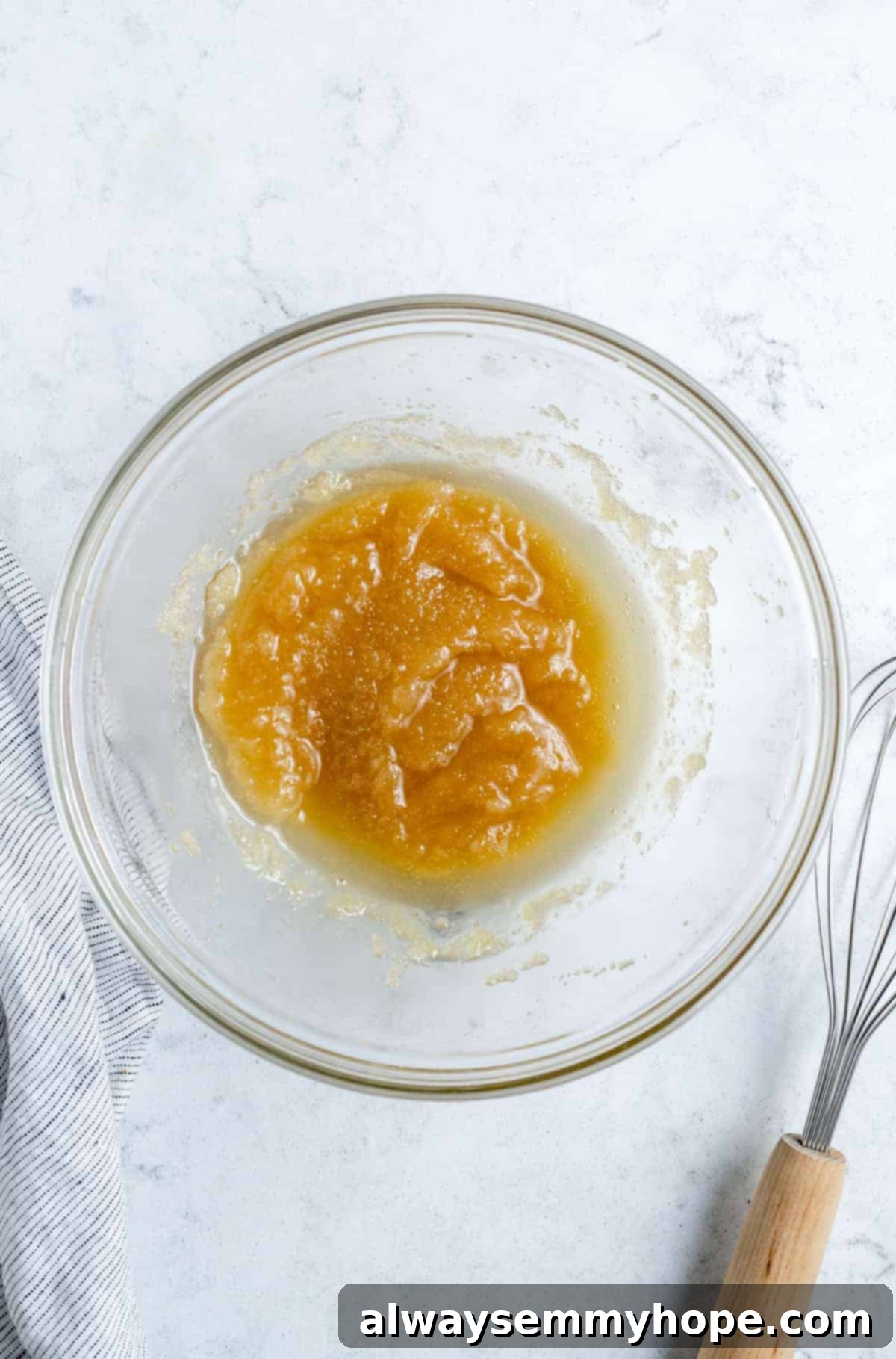 Sugar, oil, and vanilla extract being mixed in a large bowl.