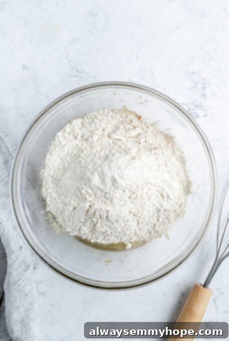Dry ingredients and wet ingredients for zucchini bread in a bowl.
