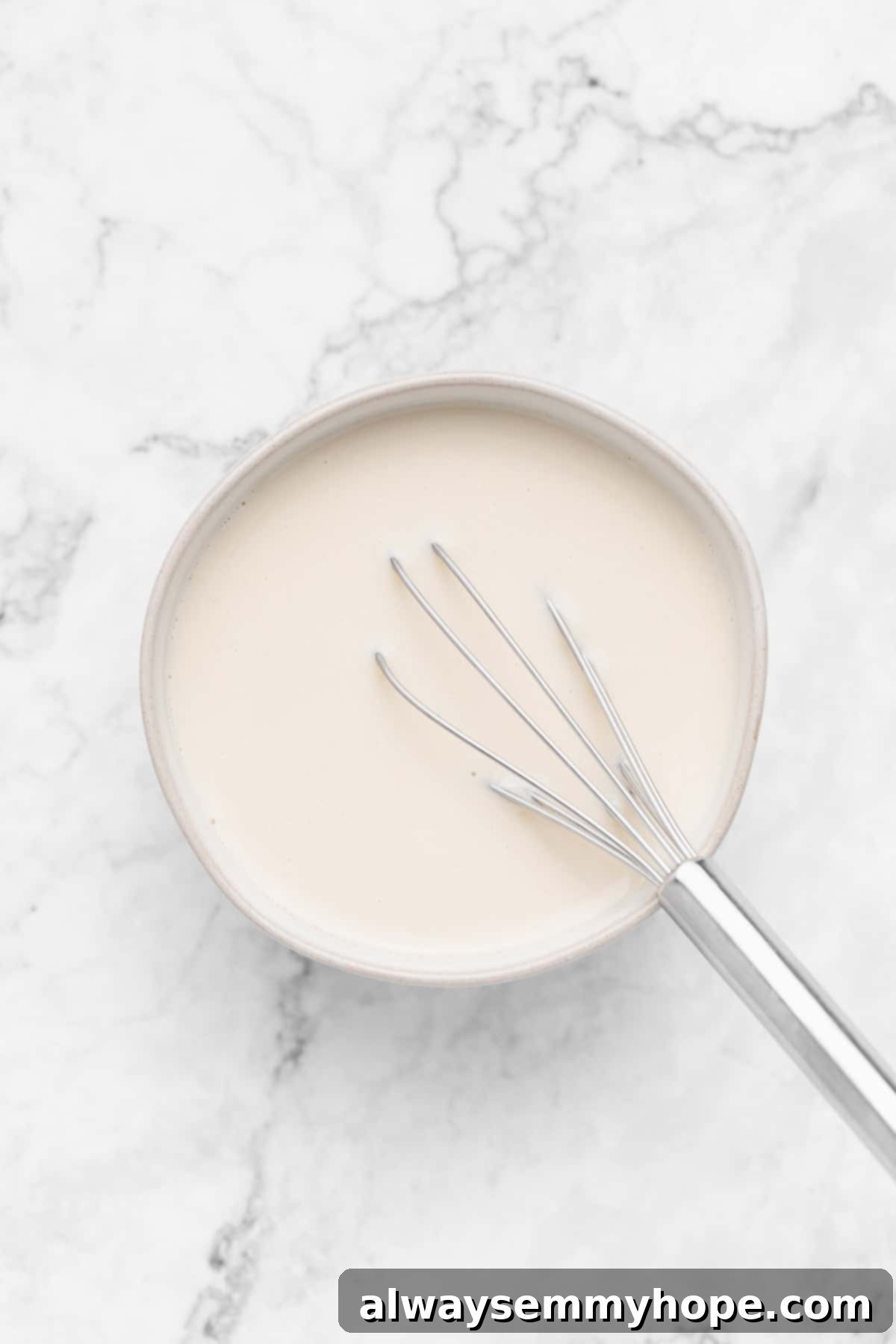 A bowl containing homemade vegan buttermilk, showing the curdled texture.
