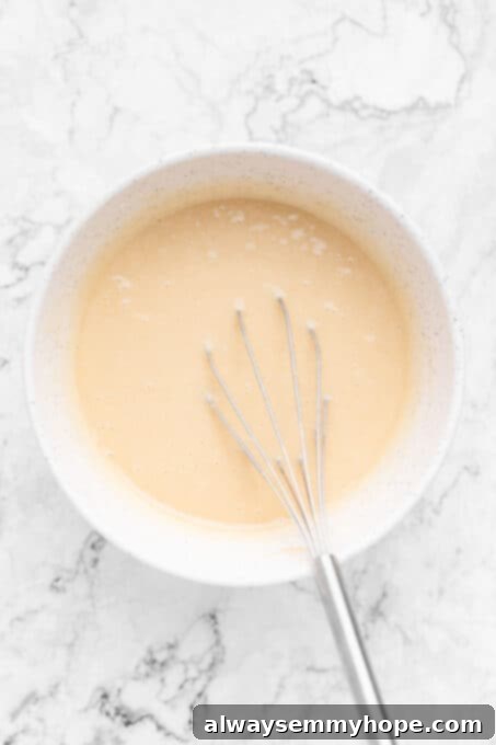 Smooth vanilla cupcake batter in a mixing bowl, perfectly combined.