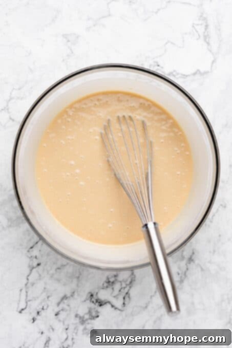 Smooth vanilla cake batter in a large mixing bowl, ready for baking.