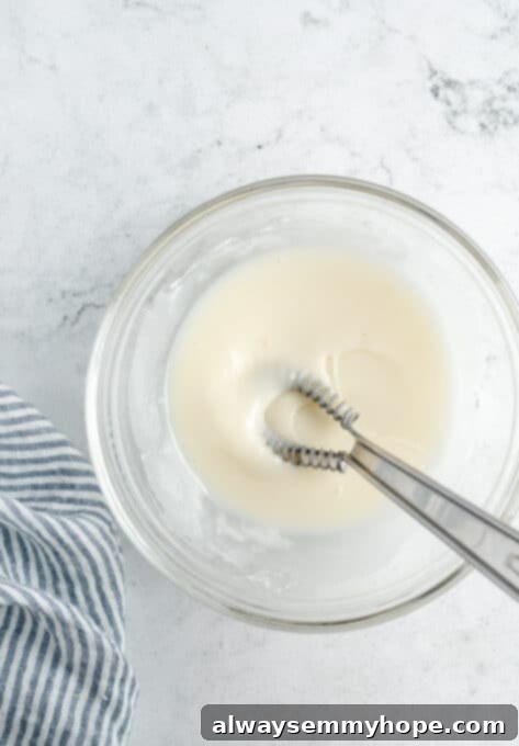 Smooth, glossy lemon-vanilla glaze in a mixing bowl, perfectly prepared.