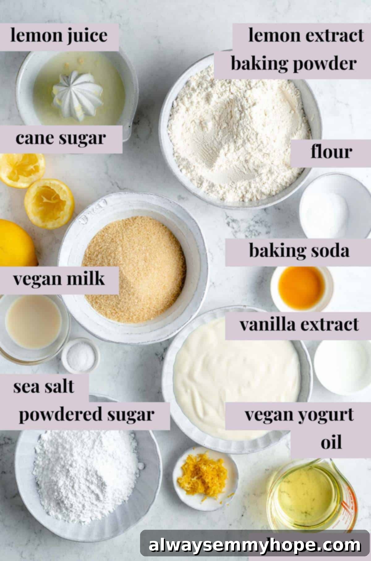 Various fresh ingredients for vegan lemon loaf, including lemons, sugar, flour, and oil, neatly arranged on a white counter.