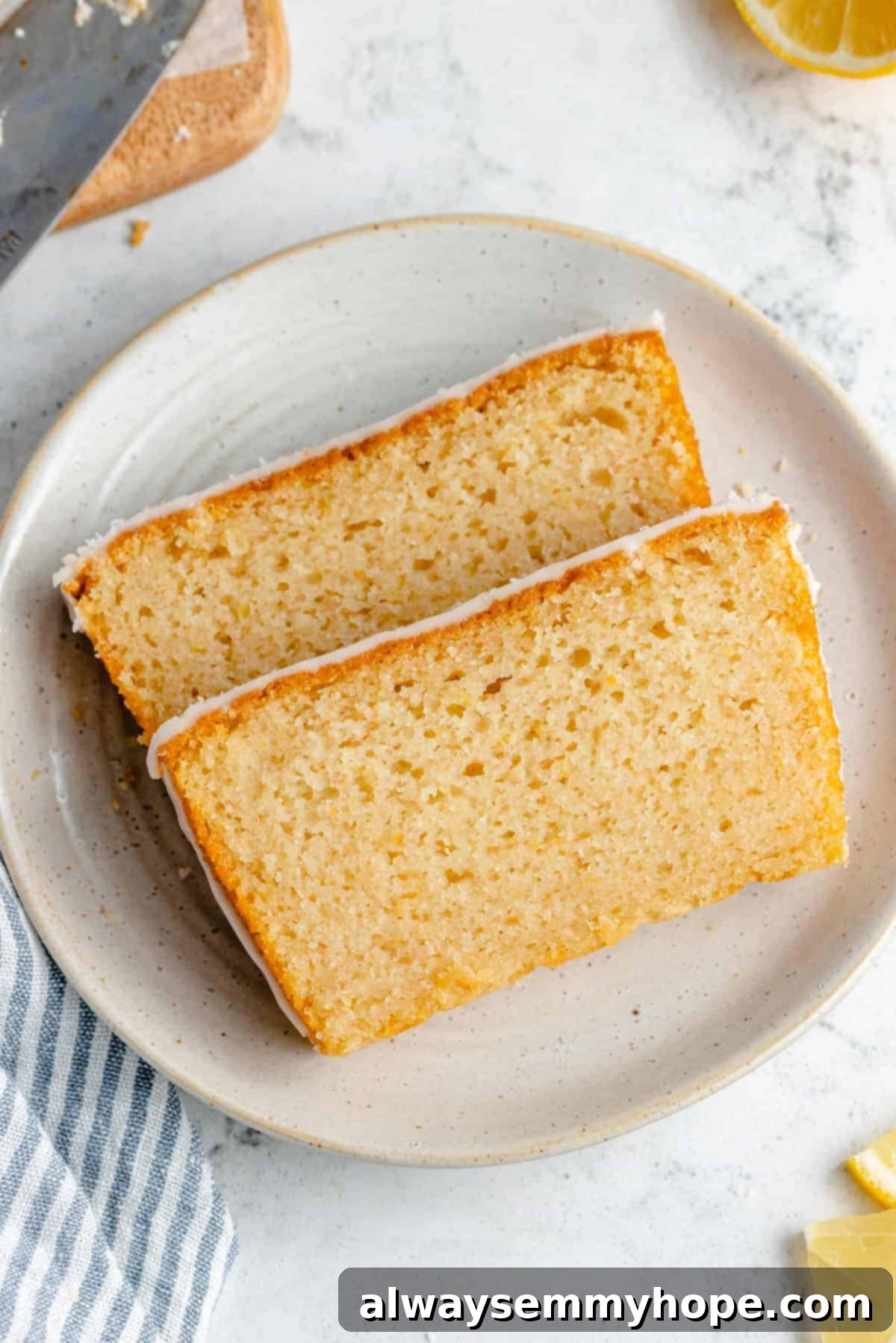 Two generous slices of glazed vegan lemon loaf cake, showcasing the moist interior and glossy glaze.