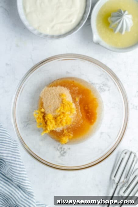 Close-up of sugar, oil, and lemon zest in a mixing bowl, ready to be combined.