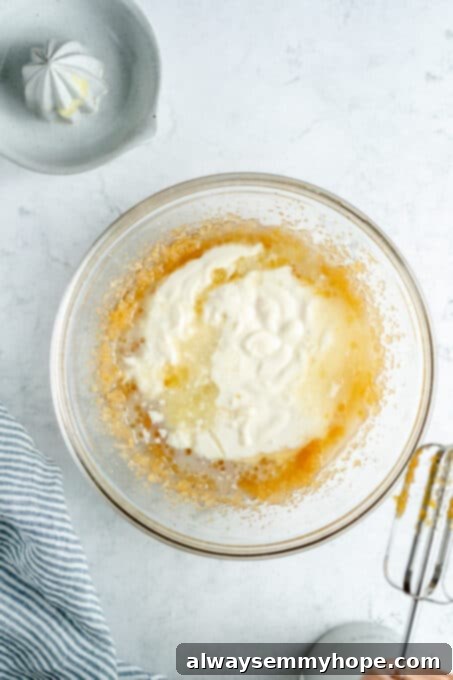 Vegan yogurt being mixed into the wet ingredients, showing a creamy texture forming.