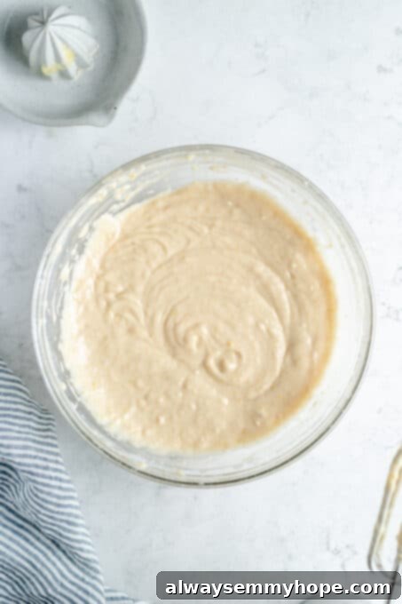 The combined lemon quick bread batter in a mixing bowl, ready to be poured.