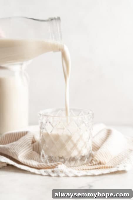 A glass bottle of soy milk next to a full glass, emphasizing its creamy texture and inviting look. Soy milk is a popular dairy alternative and a significant source of plant-based protein in vegan diets.