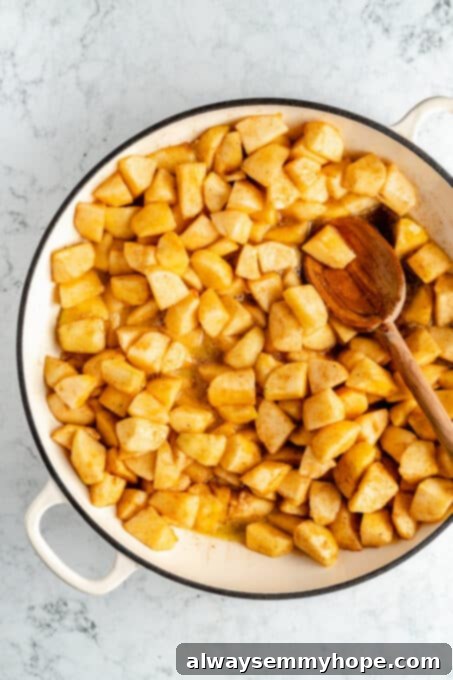 Perfect Vegan Apple Pie 8 Apples cooking gently in a large pot on the stovetop.