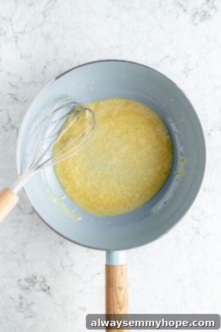 This vegan gravy is easy to make, silky smooth, and delicious over mashed potatoes! It's packed with savoury flavour, made without mushrooms. Overhead shot of a golden-brown roux cooking in a non-stick saucepan, being whisked vigorously.