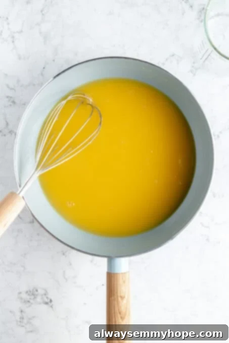 This vegan gravy is easy to make, silky smooth, and delicious over mashed potatoes! It's packed with savoury flavour, made without mushrooms. Smooth, light brown vegan gravy being whisked in a saucepan as vegetable broth is slowly poured in.