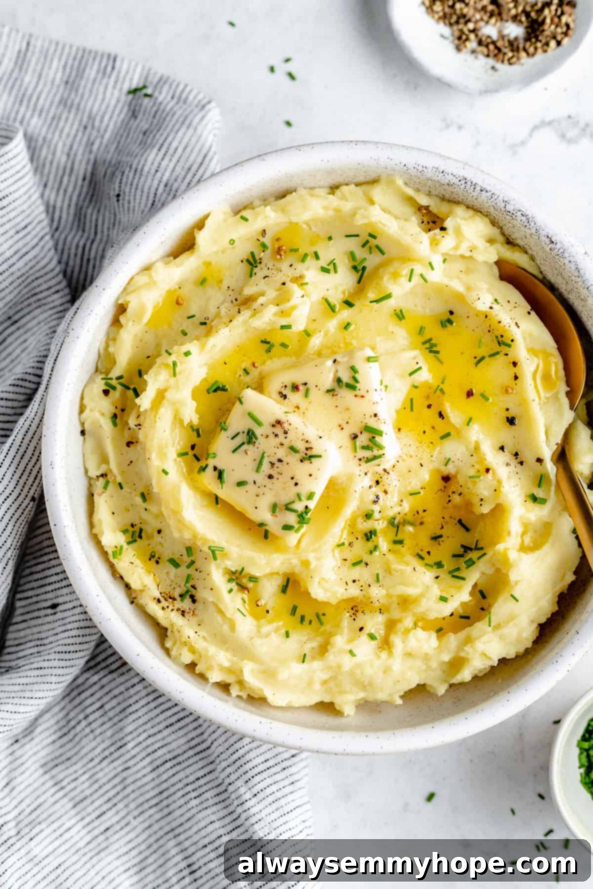 Overhead shot of mashed potatoes in bowl with gold spoon