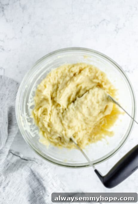 Mashed potatoes being mashed with potato masher