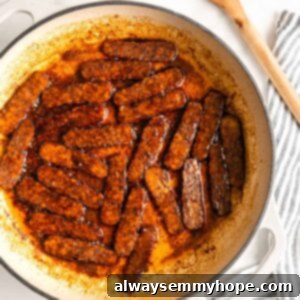 Overhead view of tempeh bacon slices being cooked in Dutch oven