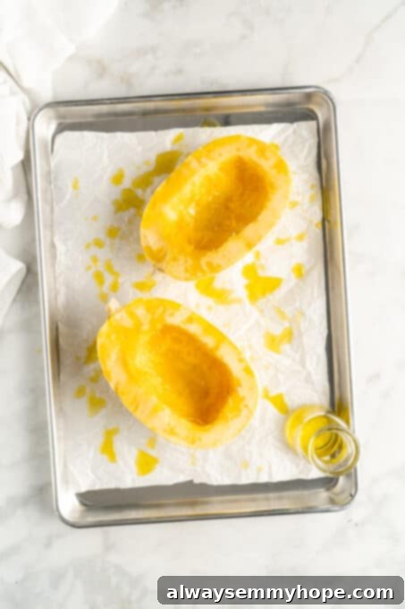 The Secret to Perfectly Cooked Spaghetti Squash 5 Overhead view of two spaghetti squash halves after drizzling with olive oil and seasoning