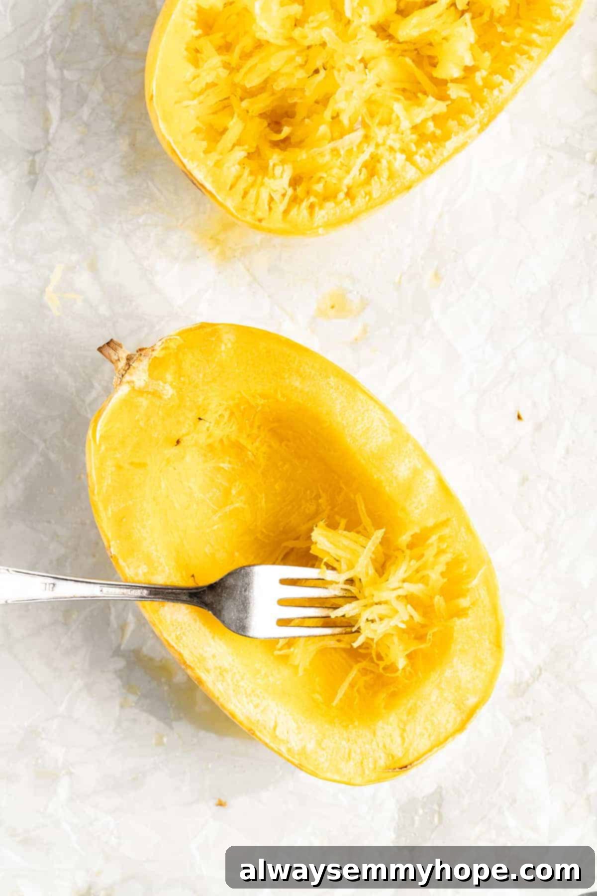 The Secret to Perfectly Cooked Spaghetti Squash 8 Close-up of two spaghetti squash halves with a fork shredding the flesh into perfect strands