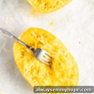 The Secret to Perfectly Cooked Spaghetti Squash 9 Two baked spaghetti squash halves with fork shredding flesh into noodles