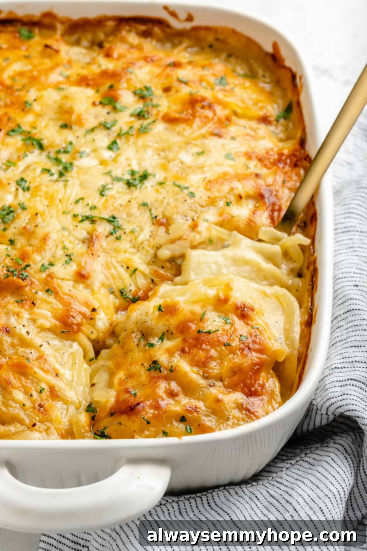 My creamy vegan scalloped potatoes are dairy-free, cheesy, and easy to make! The perfect side dish for Thanksgiving, holidays, and weeknights. Vegan scalloped potatoes in baking dish with spoon scooping out a serving