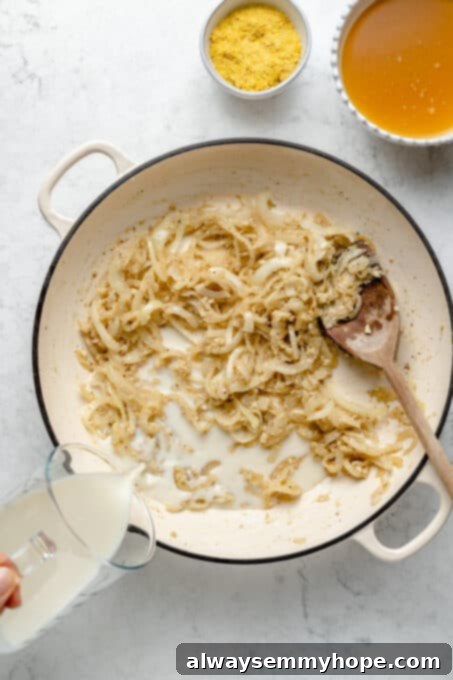 My creamy vegan scalloped potatoes are dairy-free, cheesy, and easy to make! The perfect side dish for Thanksgiving, holidays, and weeknights. Pouring almond milk into saucepan with sauteed onions