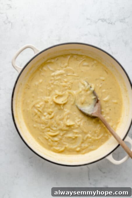 My creamy vegan scalloped potatoes are dairy-free, cheesy, and easy to make! The perfect side dish for Thanksgiving, holidays, and weeknights. Overhead view of cream sauce in pot