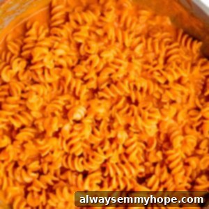 Overhead view of roasted red pepper pasta in a large skillet.