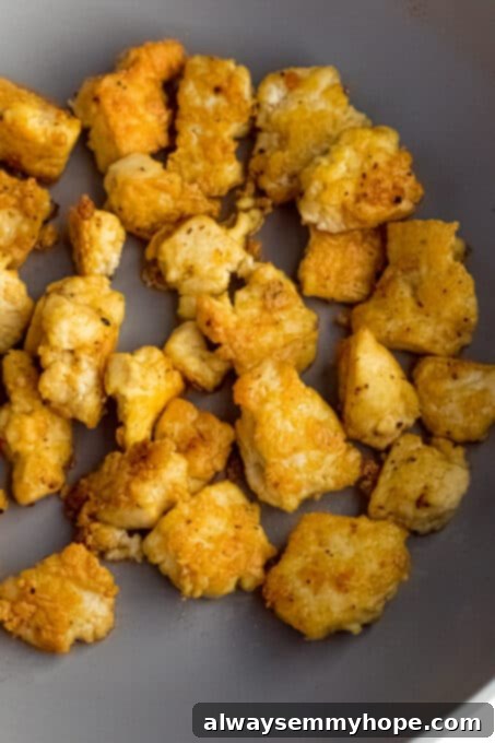 Korean Gochujang Tofu Rice Bowls 11 Golden-brown, crispy tofu pieces sizzling in a hot pan, demonstrating the perfect cooking stage.