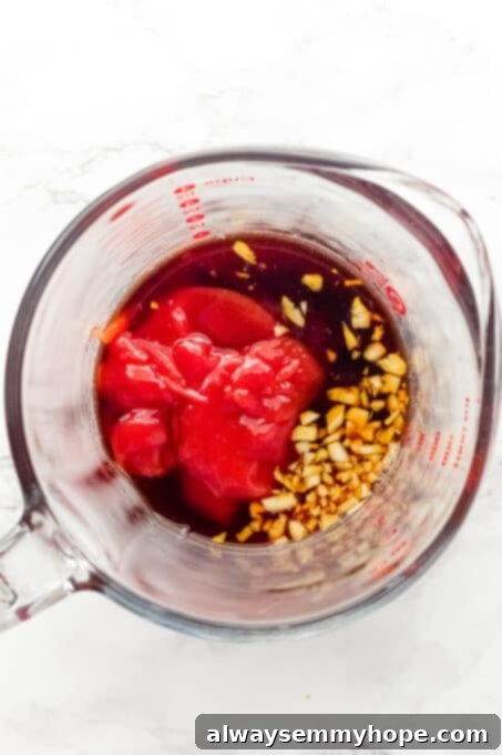 Korean Gochujang Tofu Rice Bowls 12 A glass measuring cup filled with a vibrant, whisked gochujang sauce, ready to be added to the tofu.