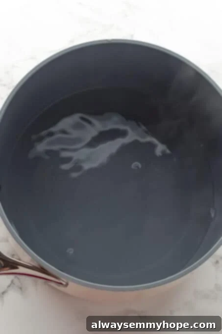 Korean Gochujang Tofu Rice Bowls 4 Pot of water boiling vigorously on a stovetop, indicating preparation for cooking rice.