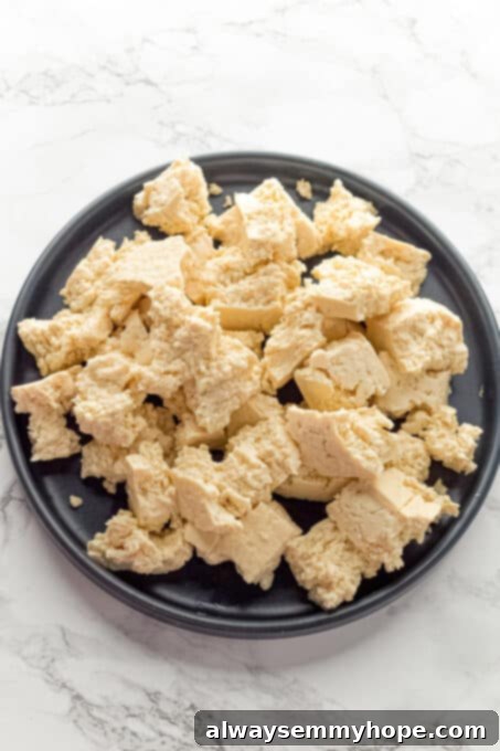 Korean Gochujang Tofu Rice Bowls 8 Pressed and torn tofu pieces arranged on a plate, ready for seasoning.