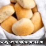 A bowl overflowing with golden, fluffy gluten-free dinner rolls, fresh out of the oven and ready to be served.