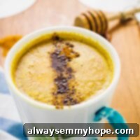 Looking down on a cozy mug of vibrant pumpkin spice golden milk, steam rising, perfect for a warming autumn drink.