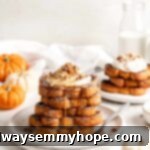 Two plates each featuring a stack of golden vegan pumpkin French toast, elegantly garnished with a swirl of whipped cream and a sprinkle of nuts.