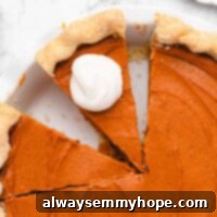 Golden Vegan Sweet Potato Bliss 2 Overhead view of a sweet potato pie with two slices cut, and one sliced topped with vegan whipped cream.