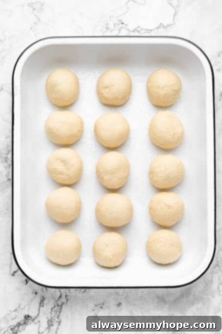 Dough balls perfectly lined up in a baking dish, ready for their final proof.