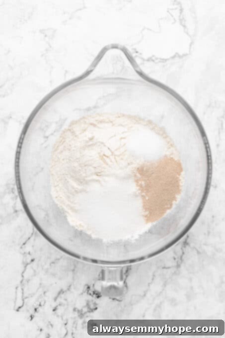 Dry ingredients for vegan dinner rolls neatly measured in a mixing bowl.