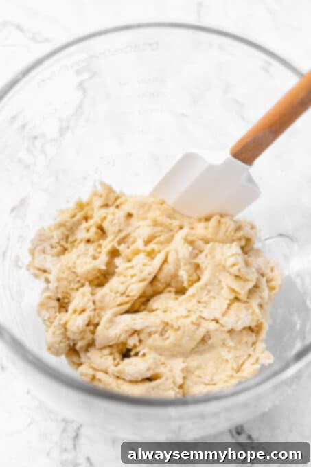 Shaggy dough ball mixed with a spatula, showing the initial texture before kneading.
