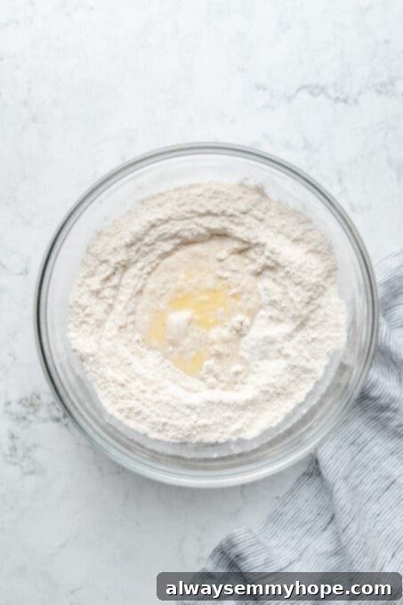 Fluffy Vegan Garlic Parmesan Dinner Rolls 5 Overhead view of dry ingredients in mixing bowl with wet ingredients poured into the centre