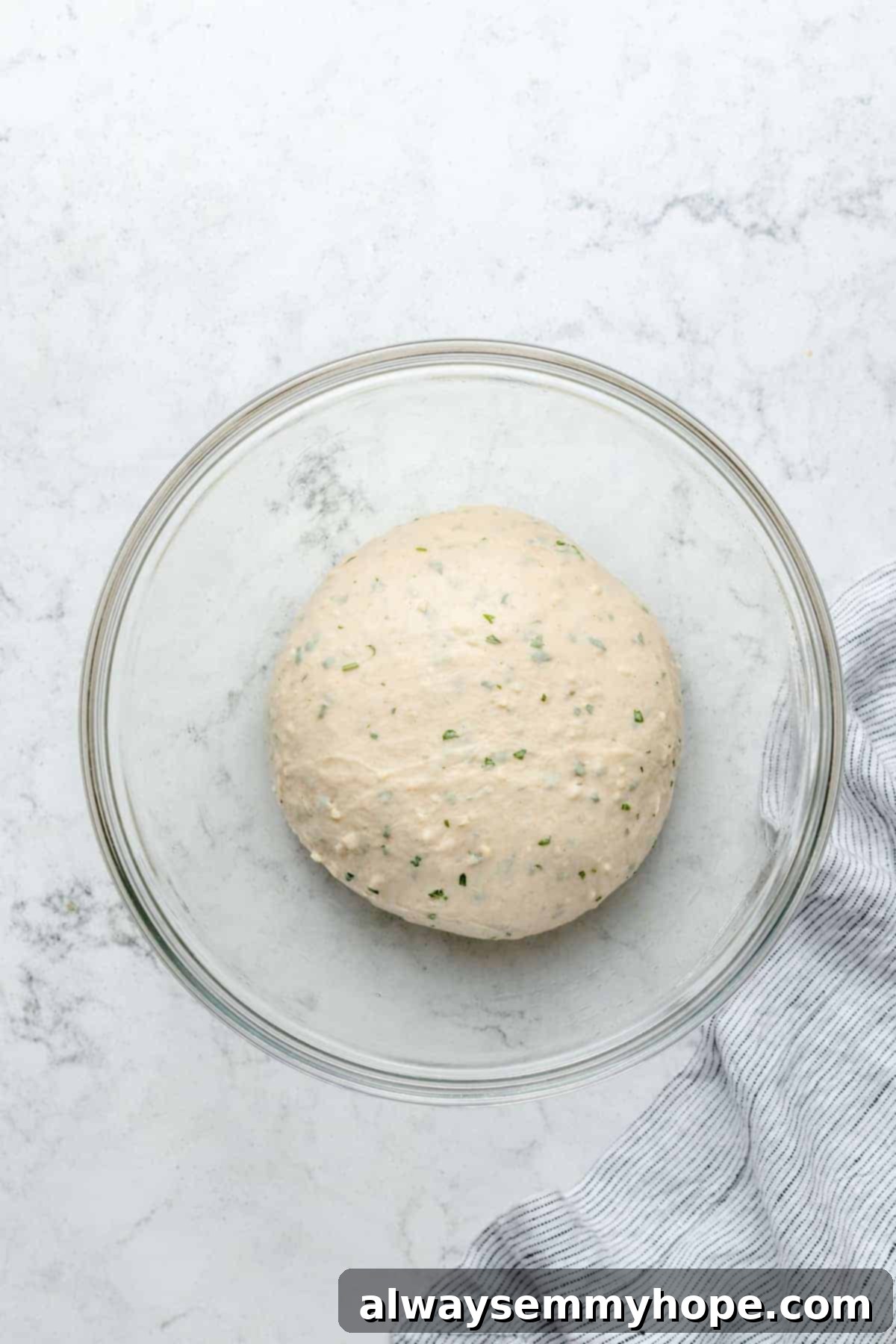 Fluffy Vegan Garlic Parmesan Dinner Rolls 8 Overhead view of dough in glass mixing bowl