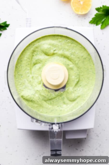Divine Green Pasta 6 A smooth, vibrant green goddess sauce, freshly blended in a food processor, showcasing its creamy texture and rich color.