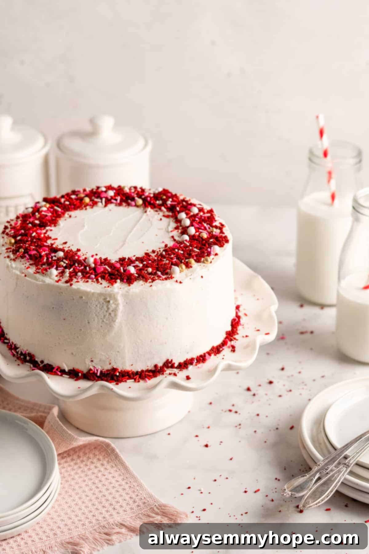 A beautifully frosted whole vegan red velvet cake sitting proudly on a cake stand, ready for slicing.