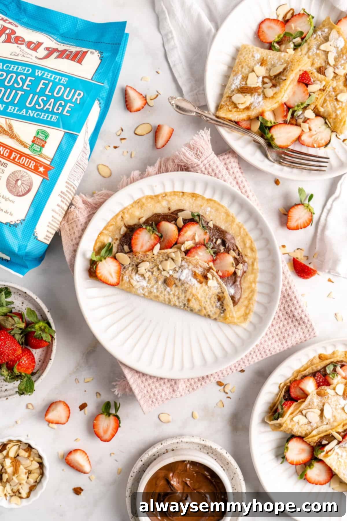 Overhead view of vegan crepes on plates with strawberries and hazelnut spread