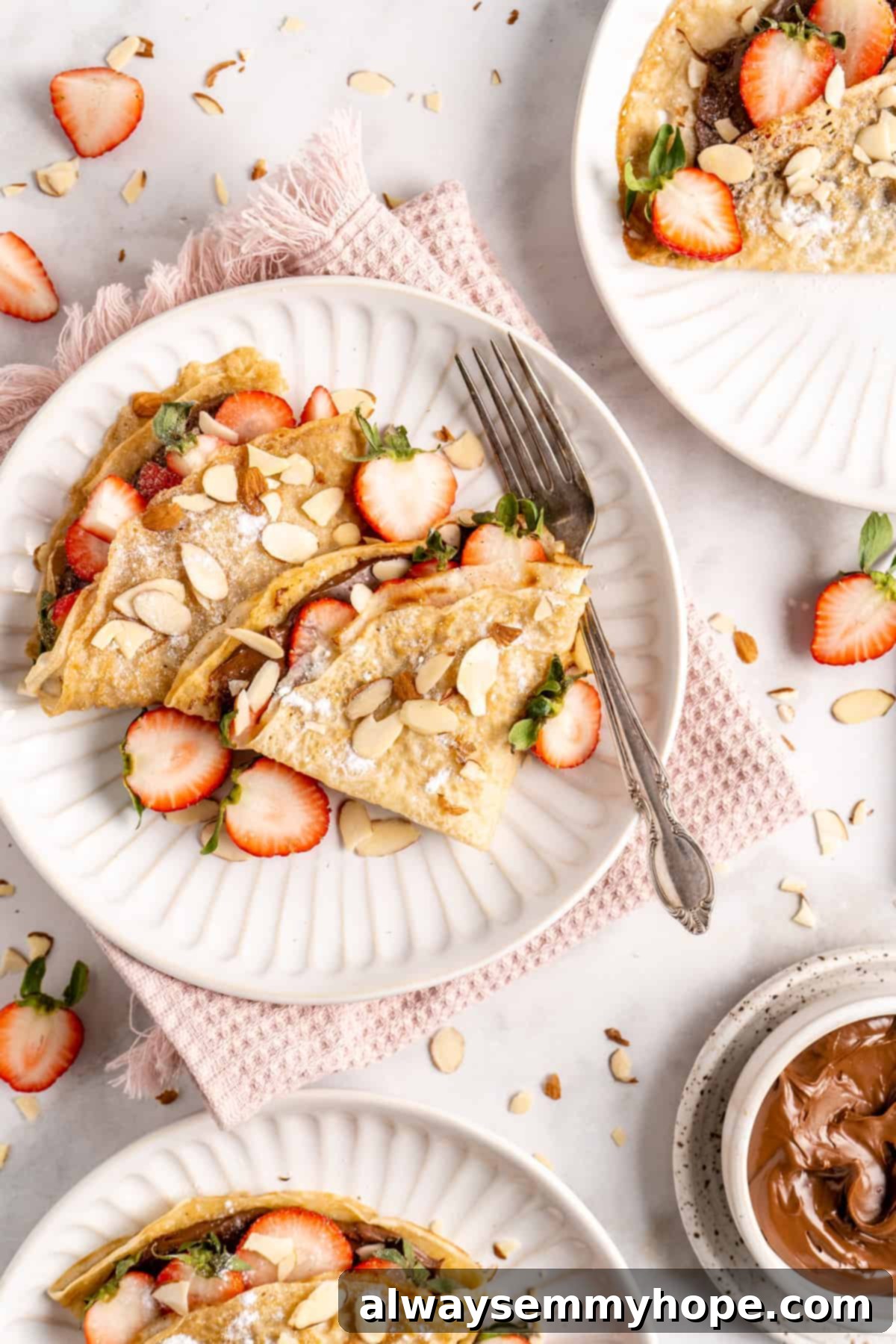 Vegan crepes on plate with strawberries and hazelnut spread