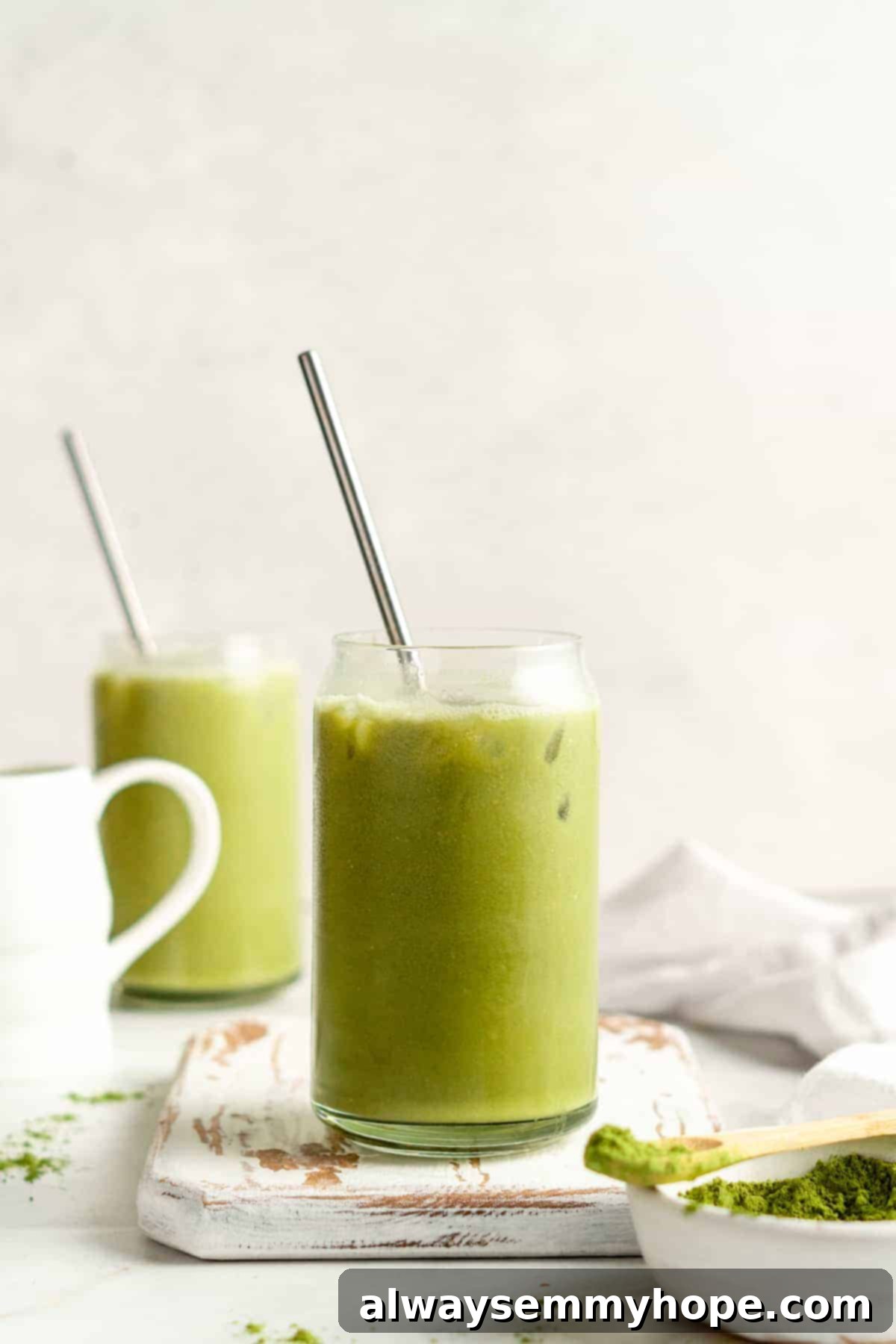 Smooth Iced Matcha Latte 15 Two vibrant iced matcha lattes in elegant glass tumblers, garnished with stainless steel straws, ready to be enjoyed.