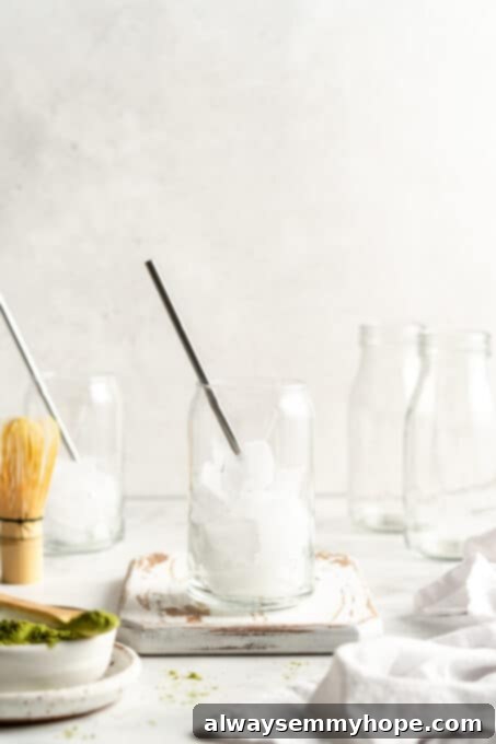 Smooth Iced Matcha Latte 10 Two clear glass tumblers filled to the brim with ice cubes, ready for drink preparation.