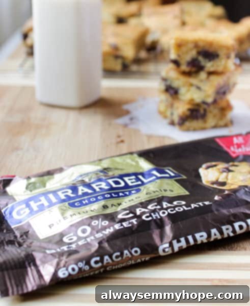 These Ghirardelli Chocolate Chip Cookie Bars were ah-mazing. Made with cream cheese and dark chocolate chips, they melt right in your mouth. A pack of baking chocolate on a wooden table.