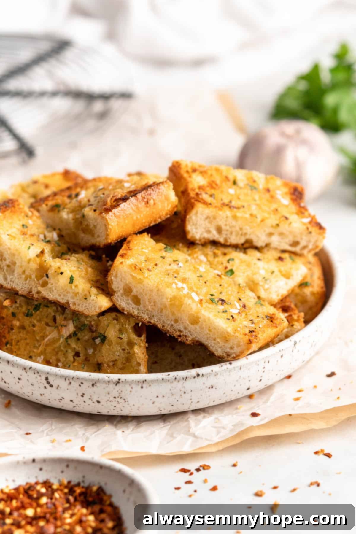 Pieces of roasted garlic bread stacked in rustic bowl, showcasing golden crust and soft interior