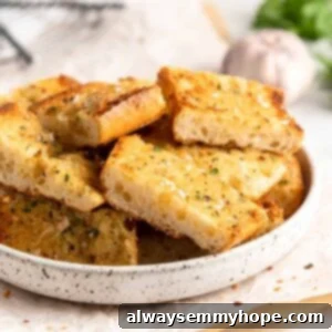 Pieces of roasted garlic bread stacked in rustic bowl