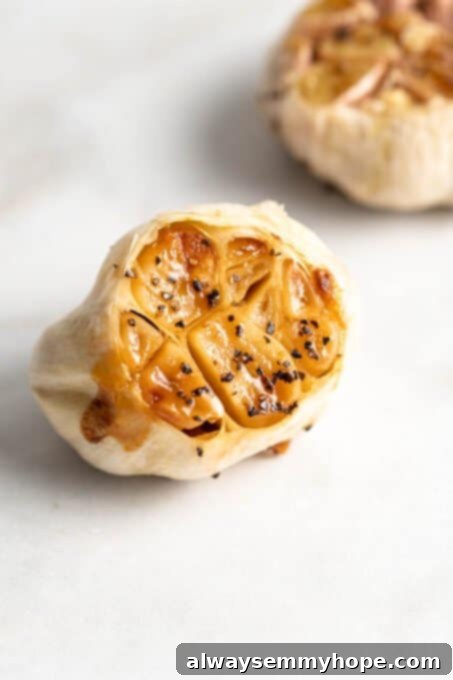 Closeup of a perfectly roasted garlic head, showing soft, golden cloves ready to be used