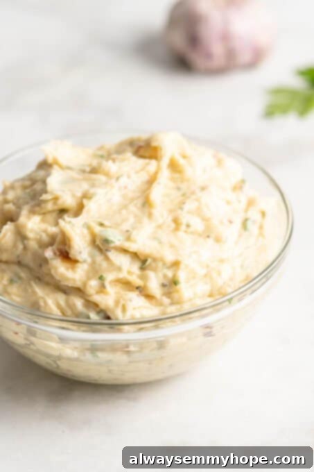 Glass bowl filled with creamy garlic butter mixture, ready to spread